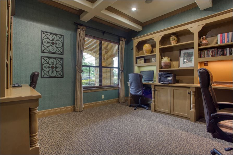 a home office with a desk and a window