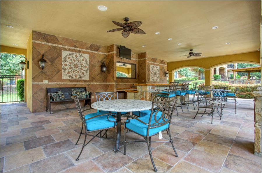 a patio with tables and chairs and a fireplace