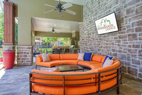 a living room with an orange couch and a ceiling fan