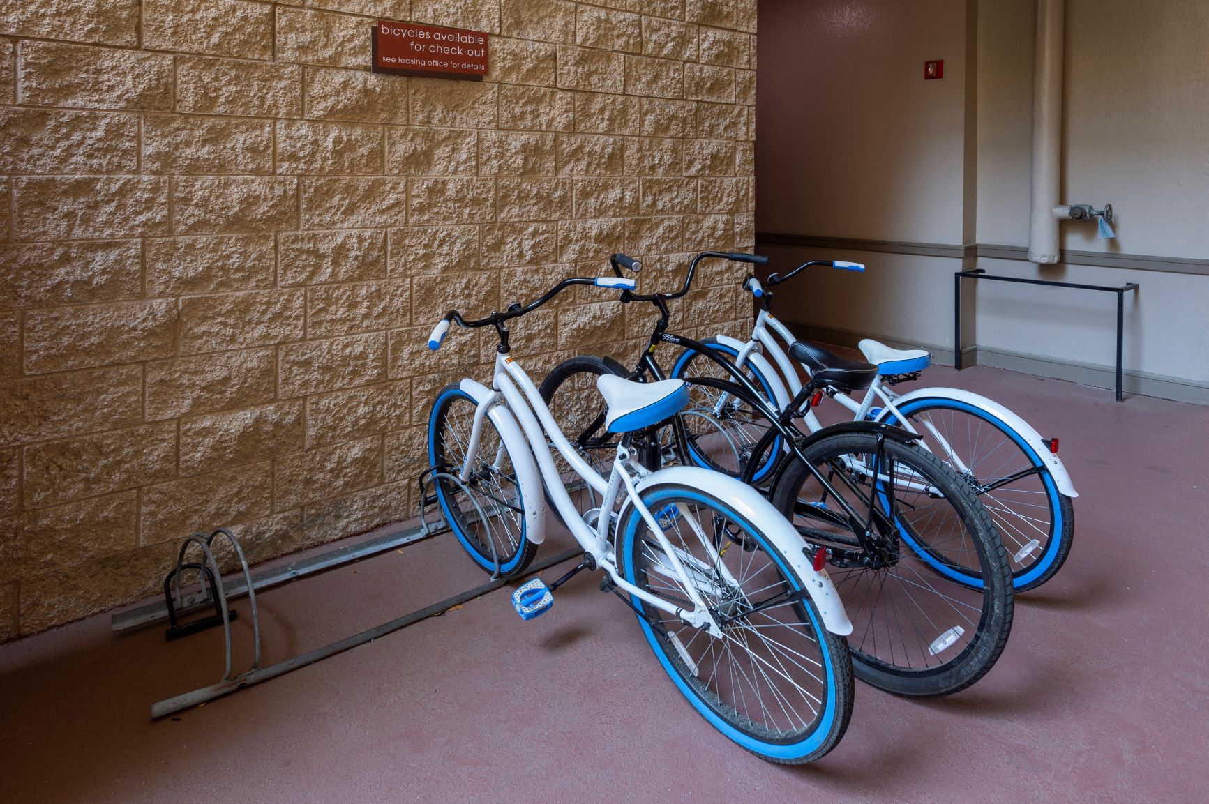 a row of bikes parked next to a wall