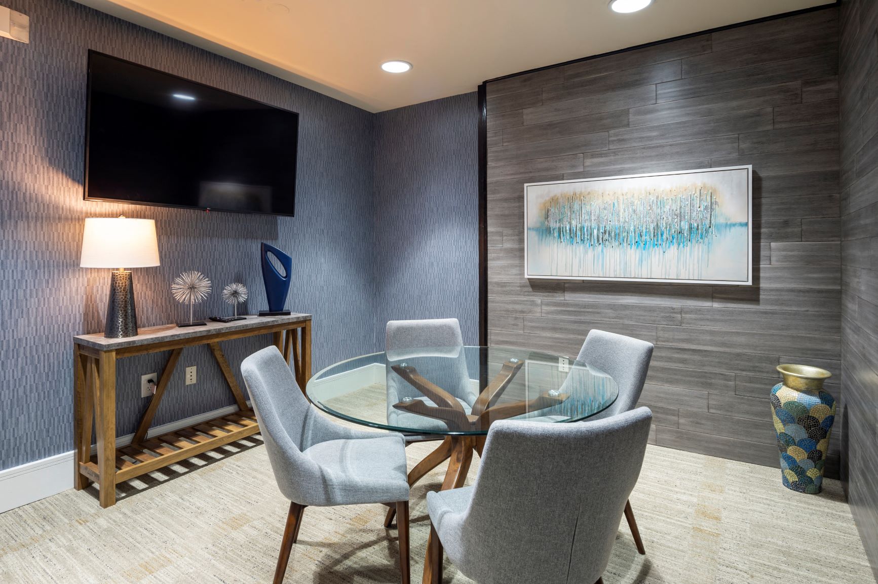 a dining room with a glass table and chairs and a tv