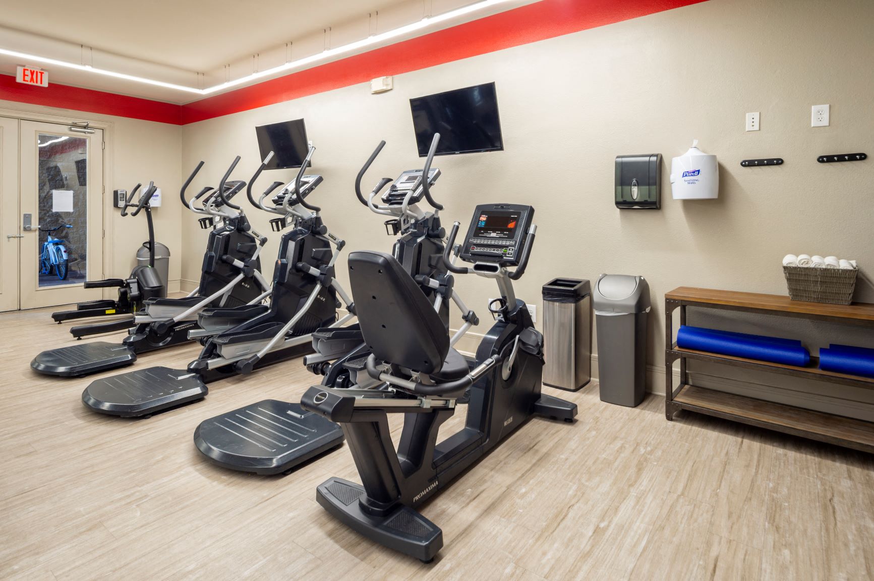 a gym with a row of exercise bikes and televisions