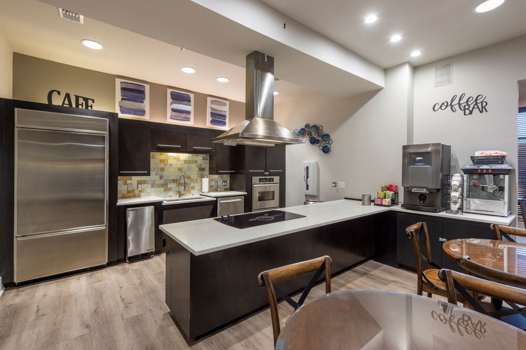 a kitchen with stainless steel appliances and a table with chairs