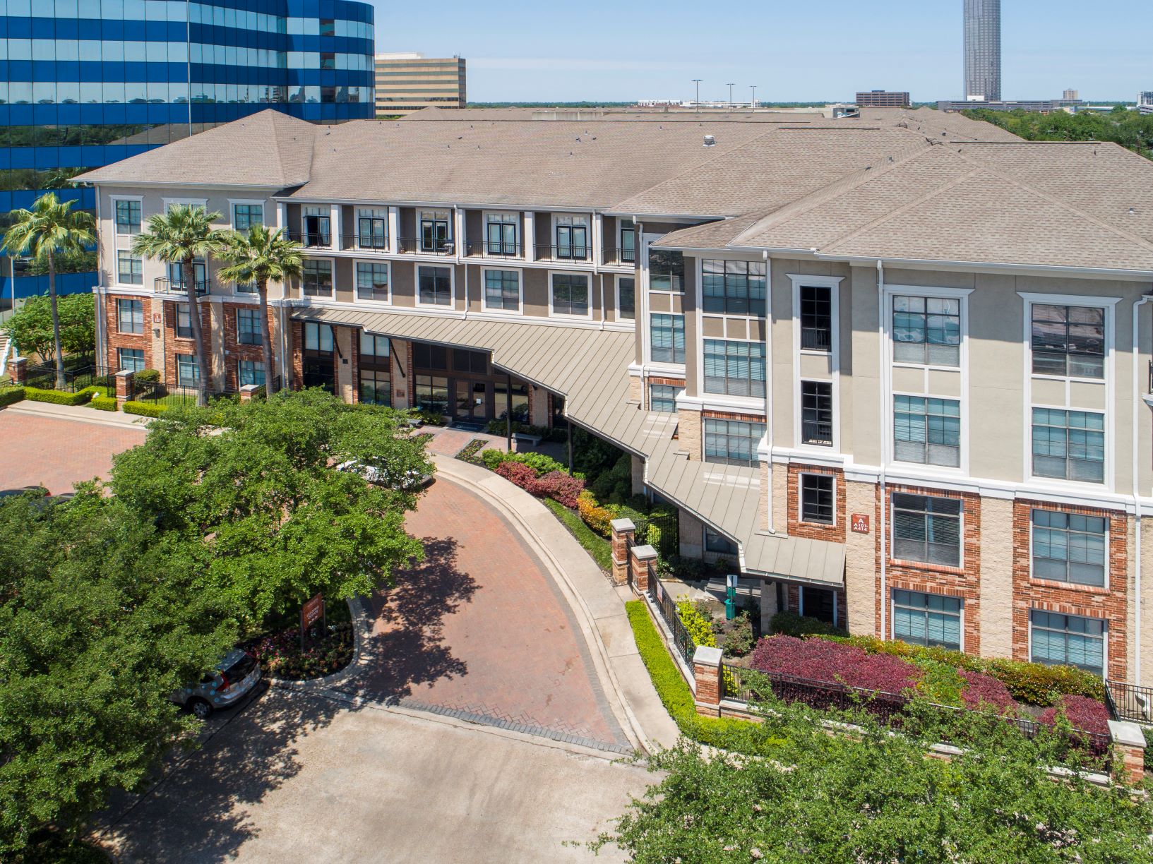 an aerial view of a large building with trees and a parking lot