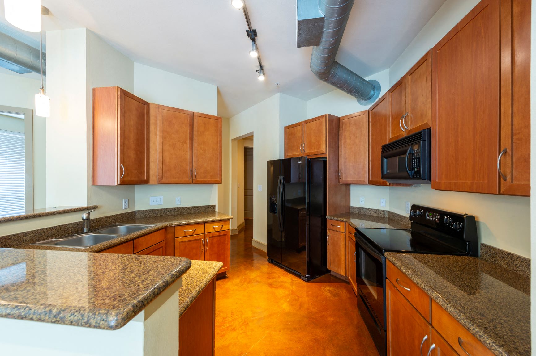 a kitchen with granite counter tops and black appliances