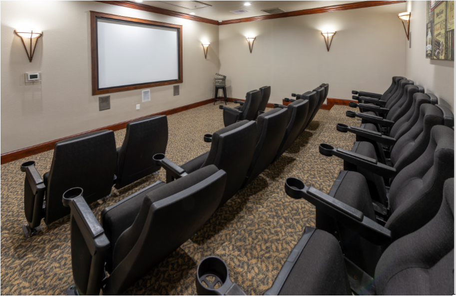a theater room with black chairs and a projector screen