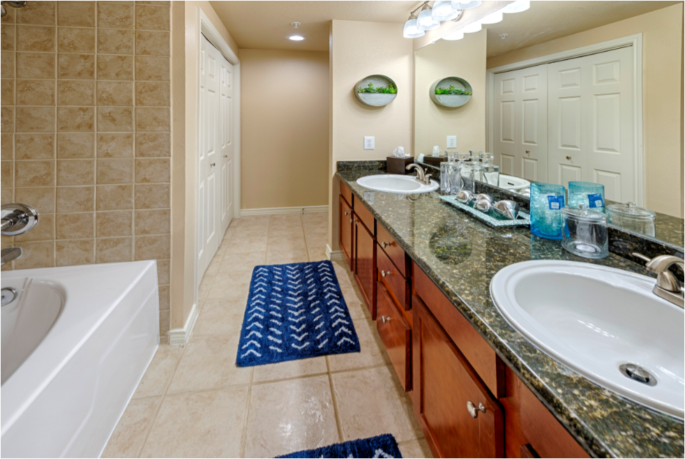 a large bathroom with two sinks and a tub