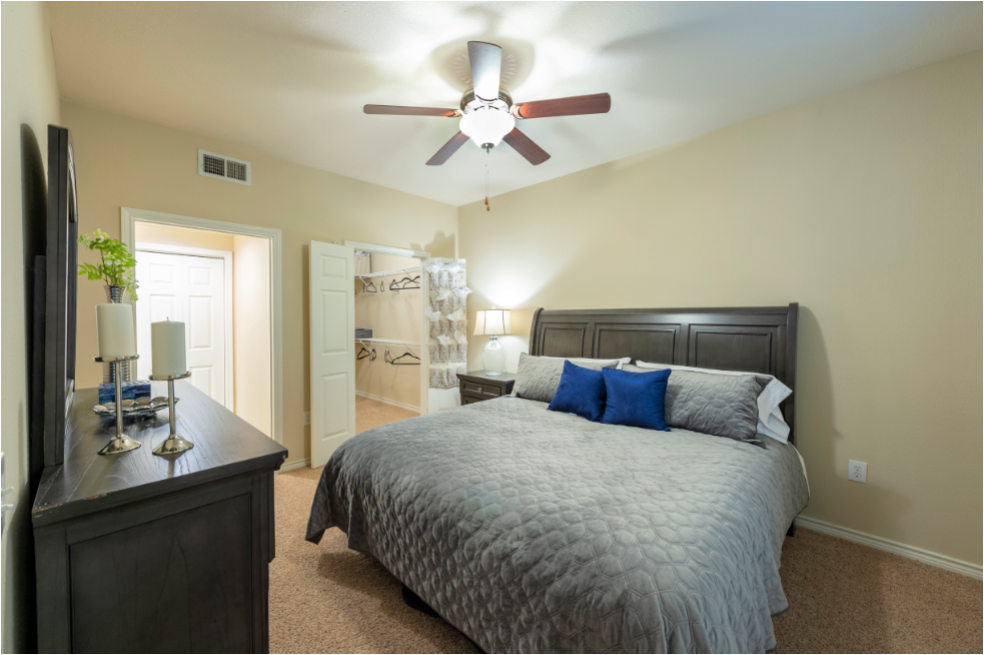 a bedroom with a large bed and a ceiling fan