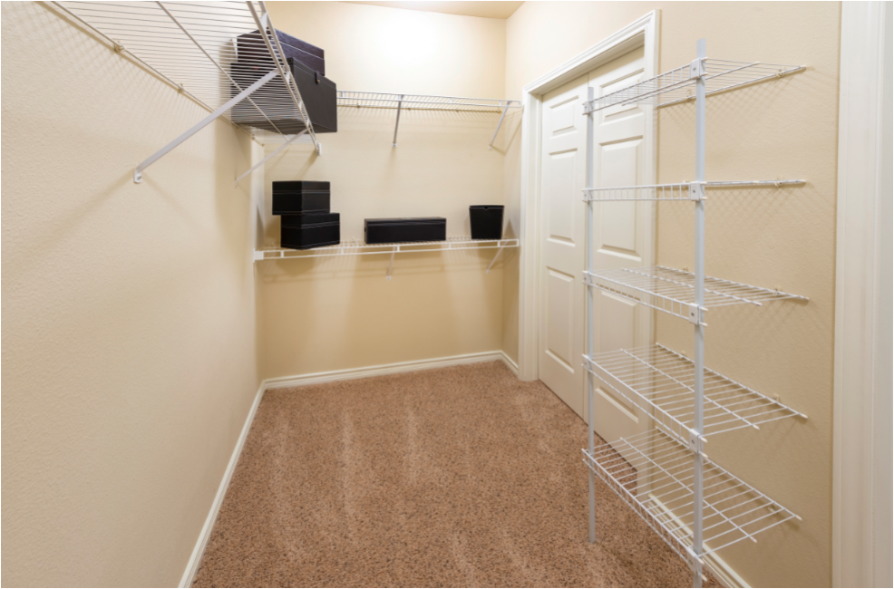 a spacious walk in closet with a mirrored closet door and shelves