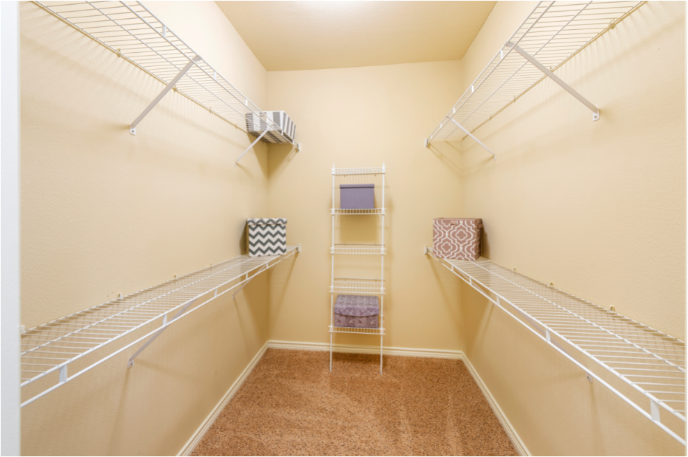 a spacious walk in closet with two racks and a ladder