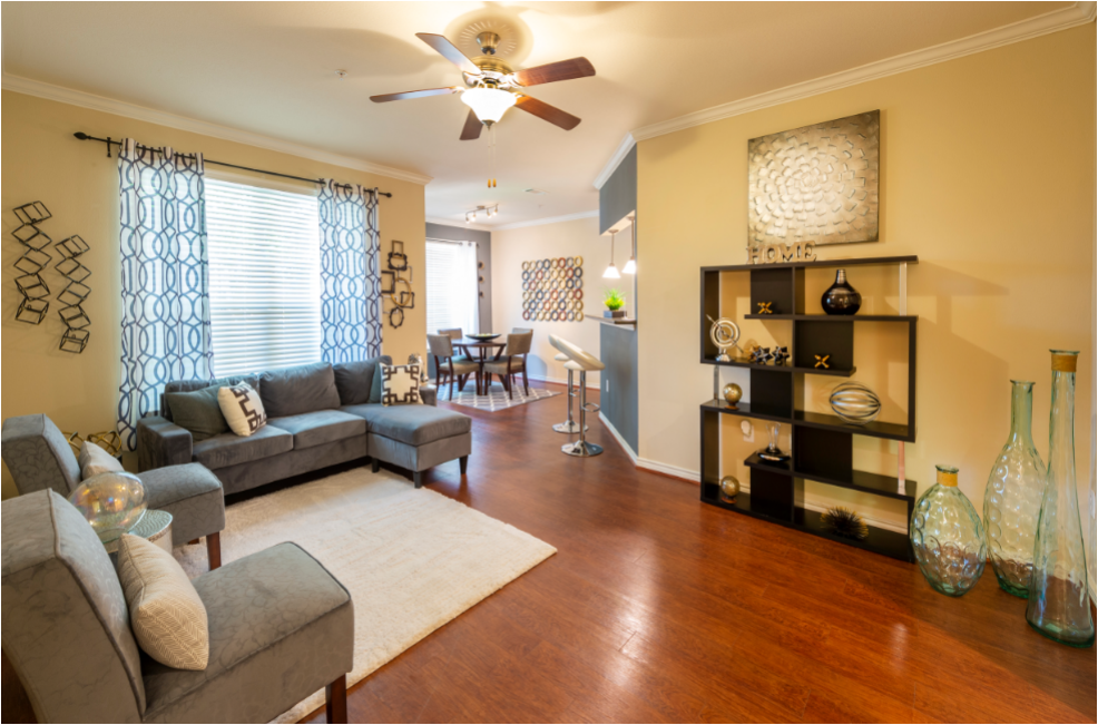 a living room with a ceiling fan and couches