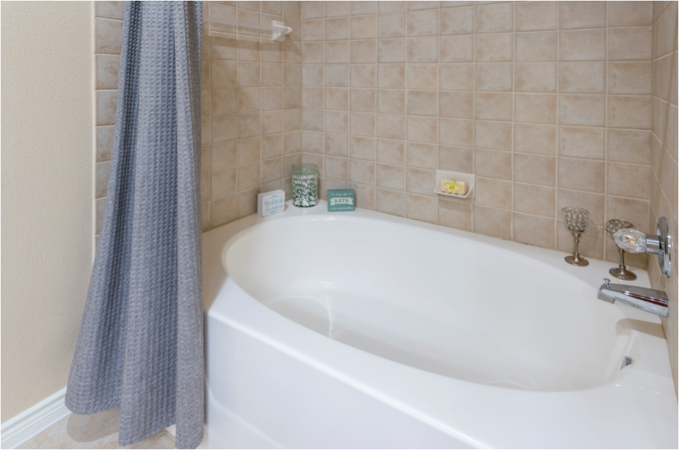 a white bath tub in a bathroom with a shower curtain