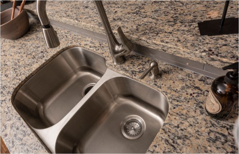 A modern stainless steel kitchen sink with a faucet.