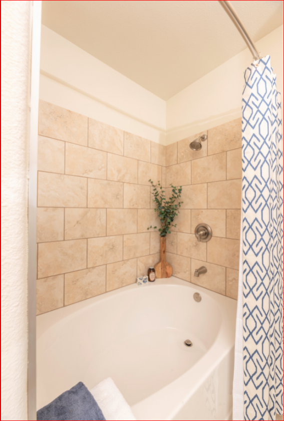 the bathroom has a large tub and a shower with a curtain