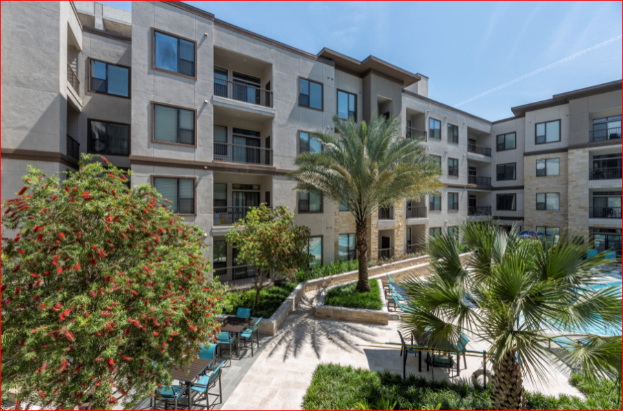 a large apartment building with a pool and palm trees