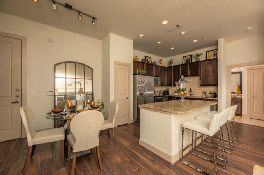 a kitchen and dining room with a marble counter top and a table and chairs