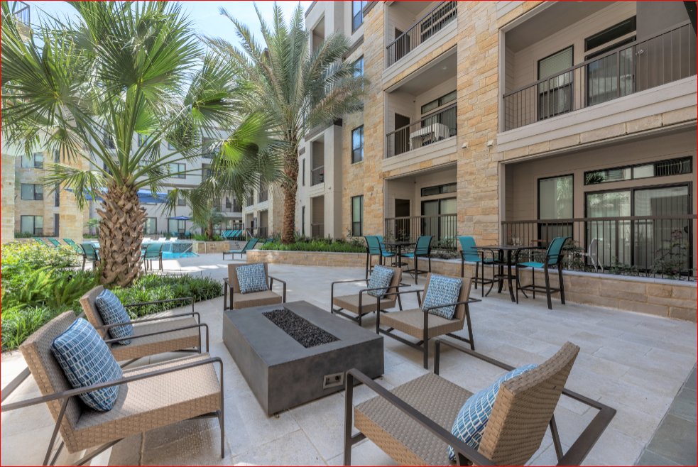 an outdoor patio with chairs and tables and a fire pit