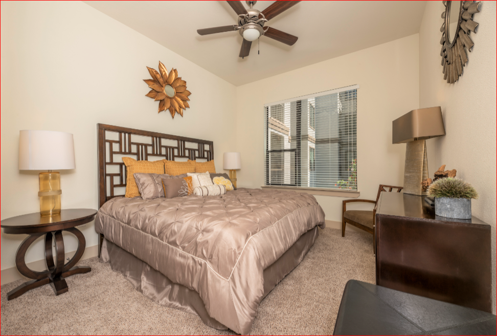 a bedroom with a large bed and a ceiling fan