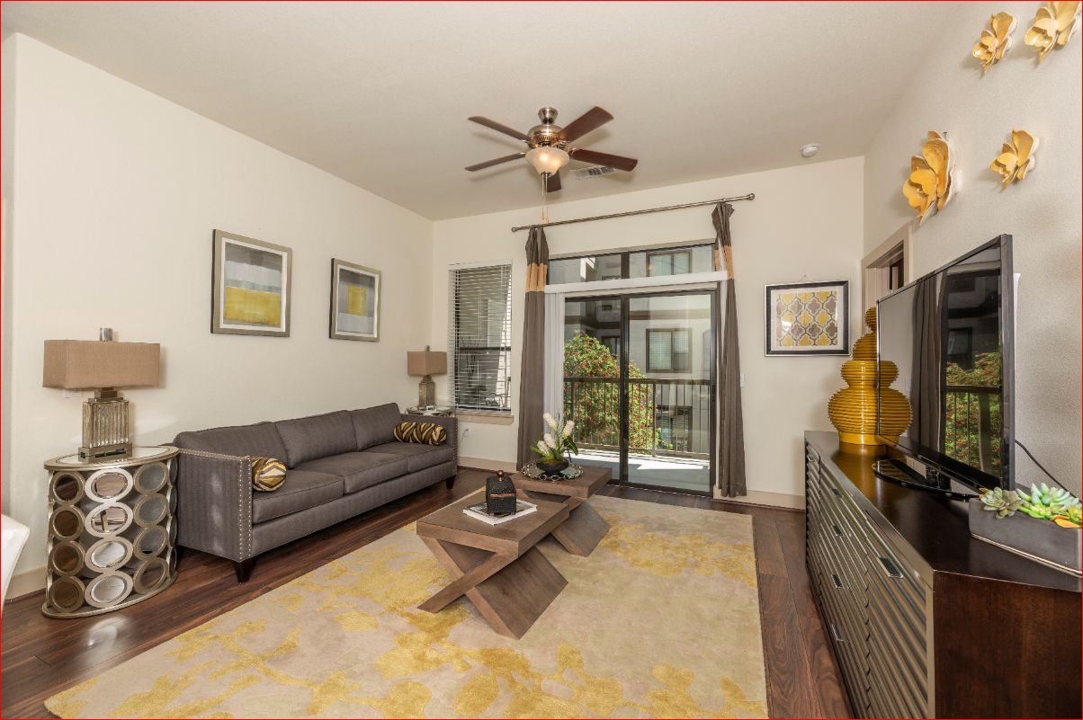 a living room with a couch and a ceiling fan