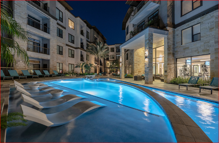 a swimming pool in the middle of an apartment building at night
