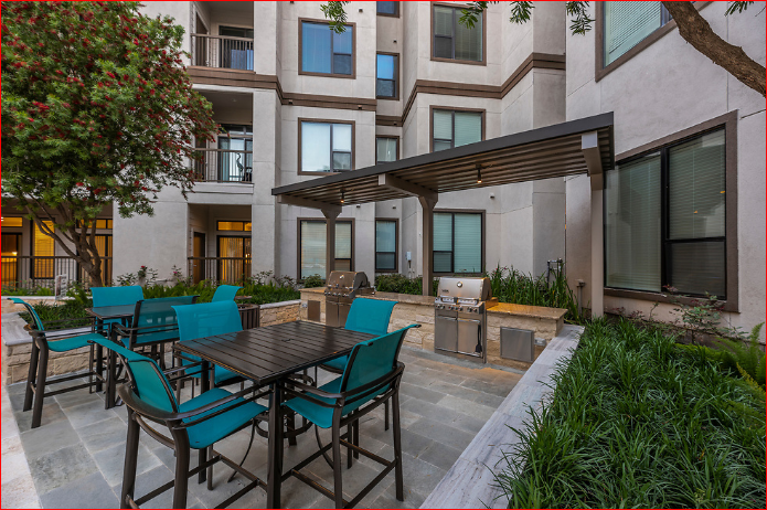 a patio with tables and chairs in front of a building