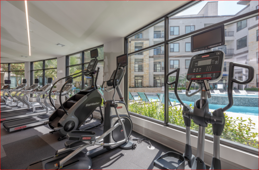 a gym with cardio equipment and a view of a swimming pool