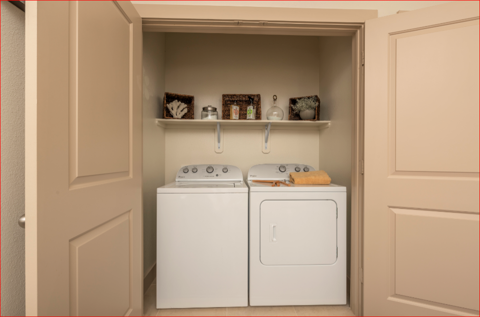 a white washer and dryer in a laundry room with a shelf above them