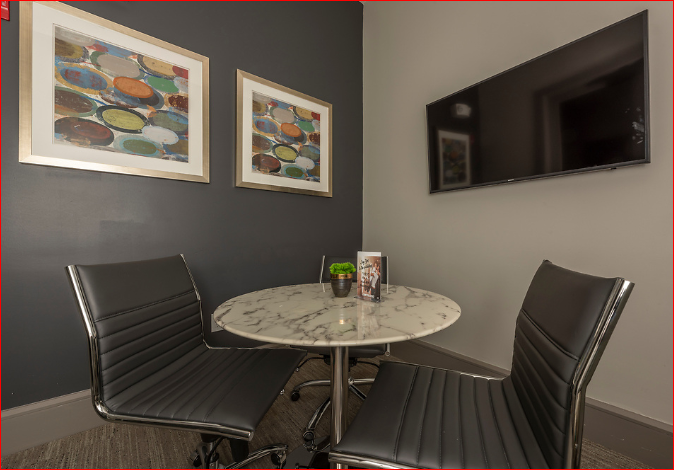 a small dining area with a table and chairs and a television