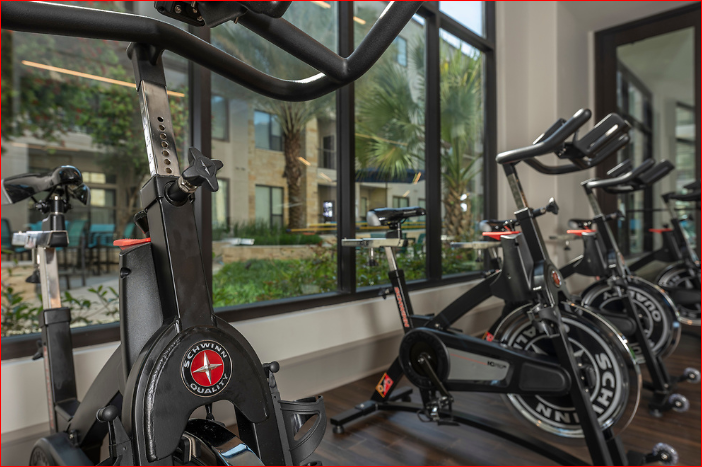 a group of bikes in a gym with a window