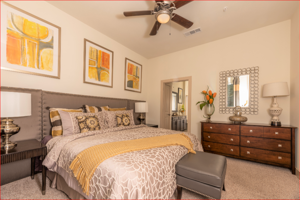 a bedroom with a large bed and a ceiling fan