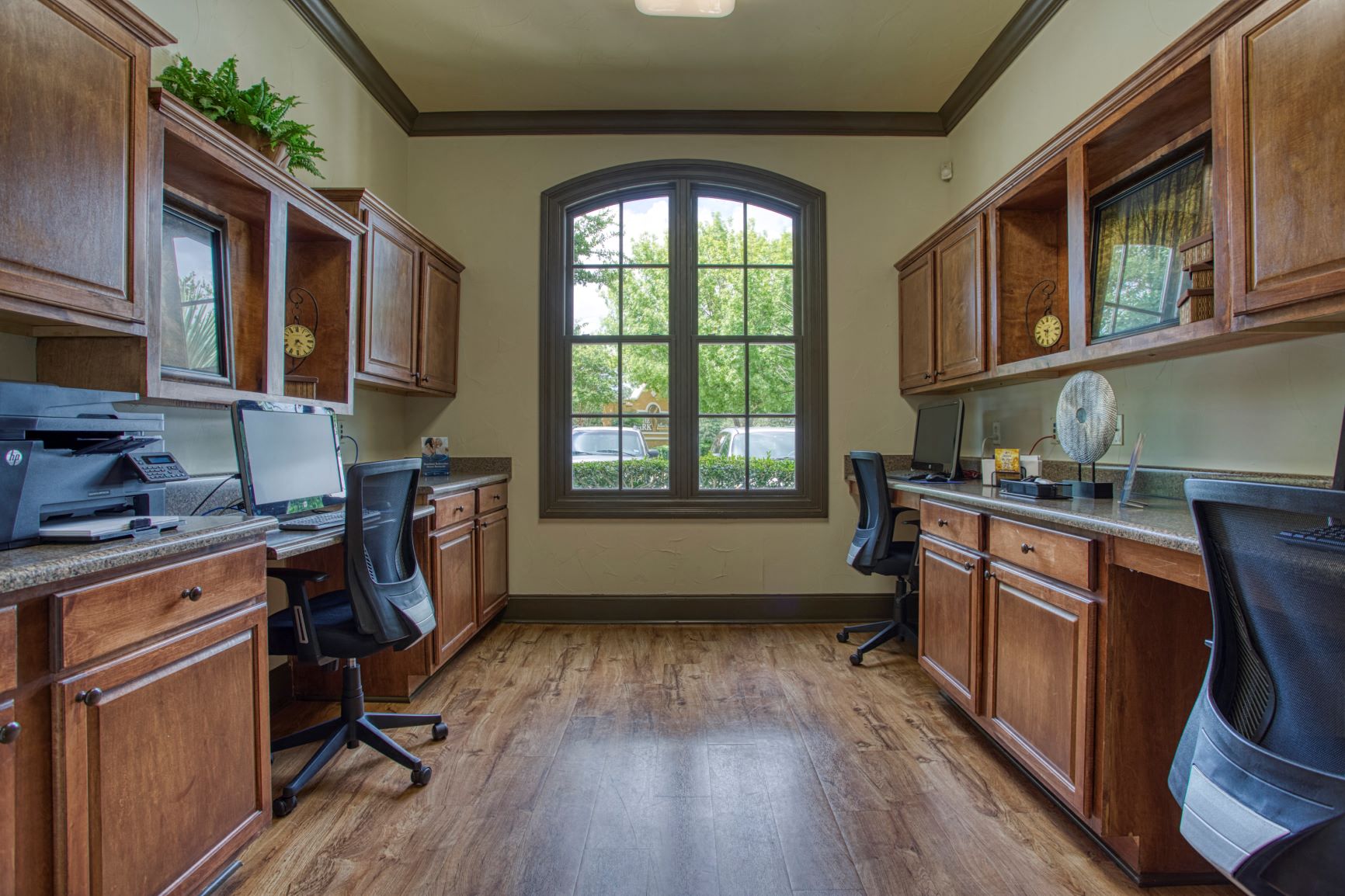 a home office with two desks and a window