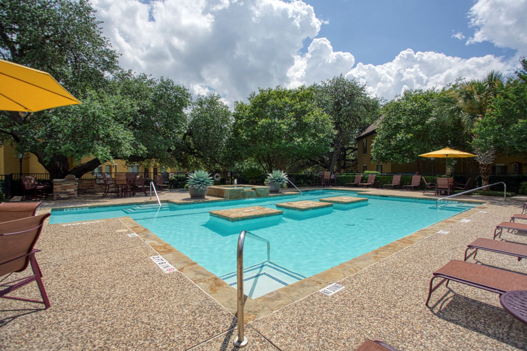 a swimming pool with chairs and umbrellas at a resort