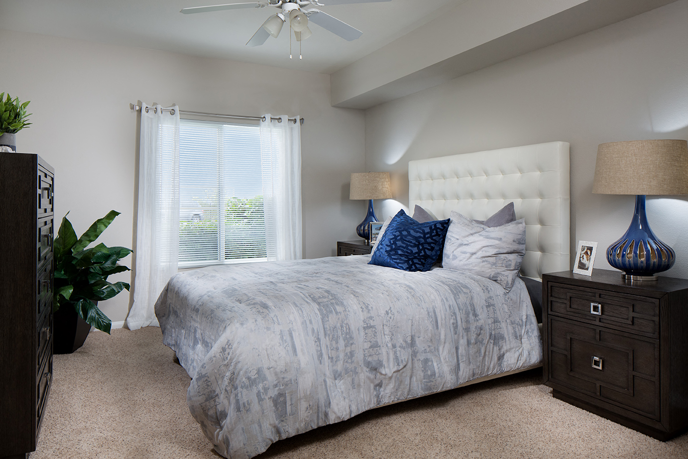 A bedroom with a large bed and a ceiling fan.