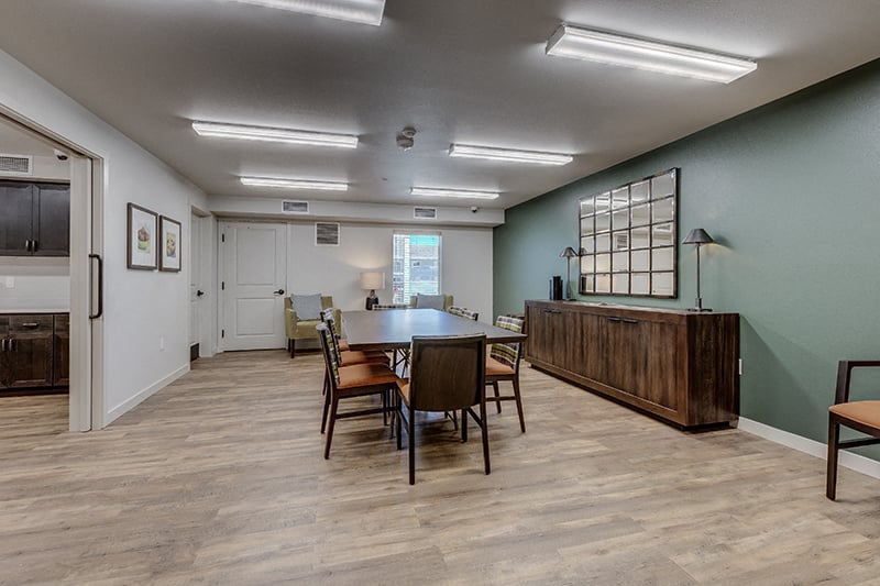 A dining room with a wooden table and chairs.