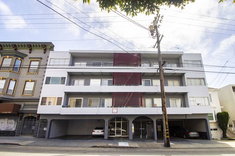 A white apartment building with a red stripe on the side.