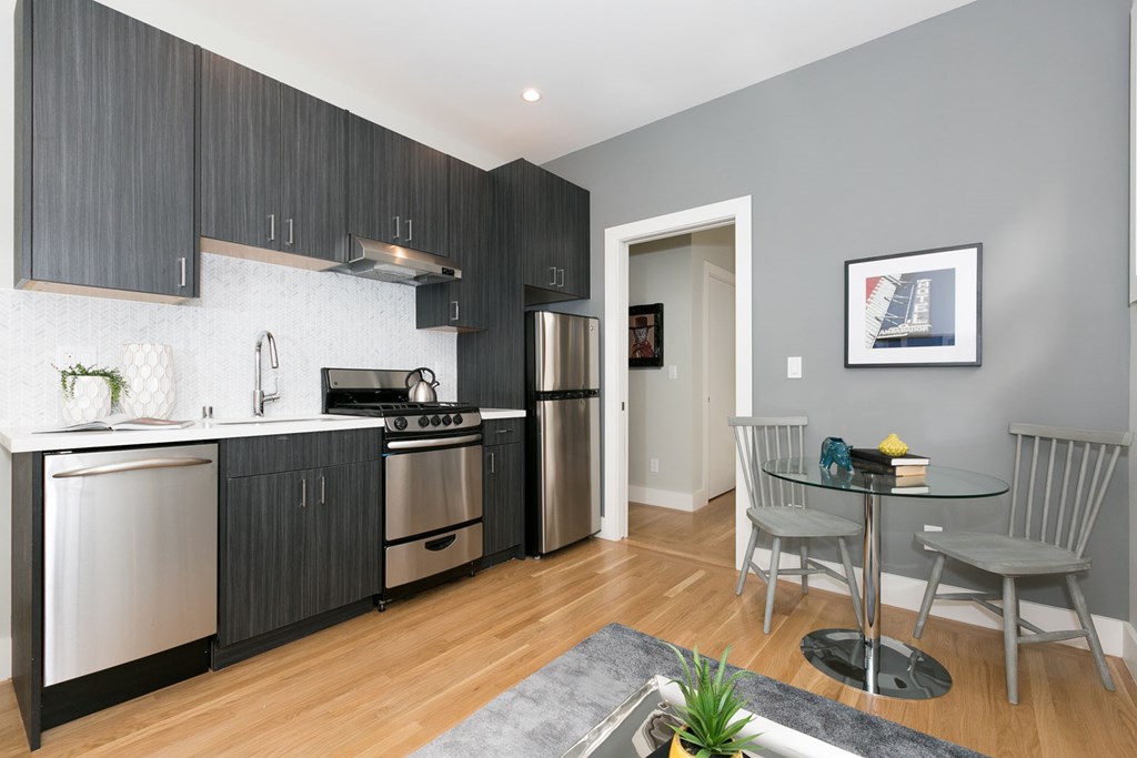A modern kitchen with a dining table set for two.