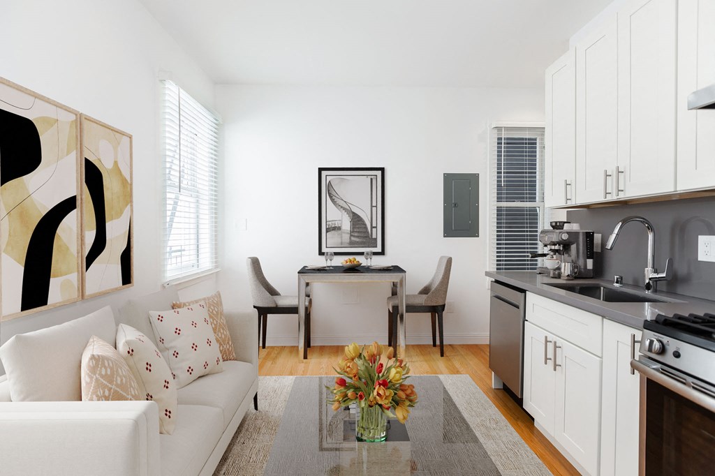 A modern kitchen with a white couch and a painting on the wall.