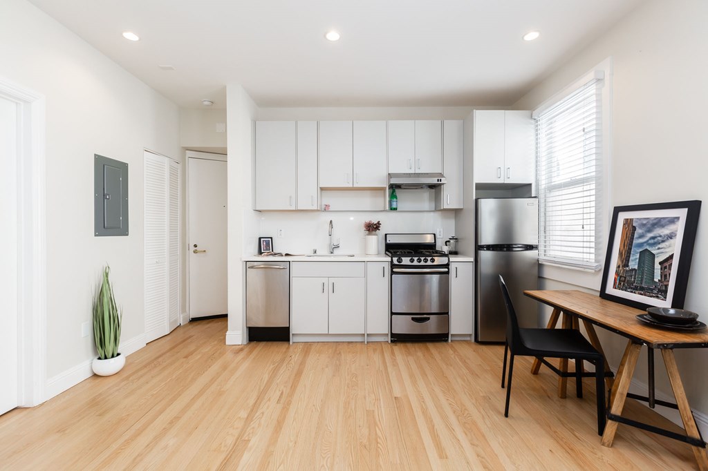 a kitchen with white cabinets and stainless steel appliances