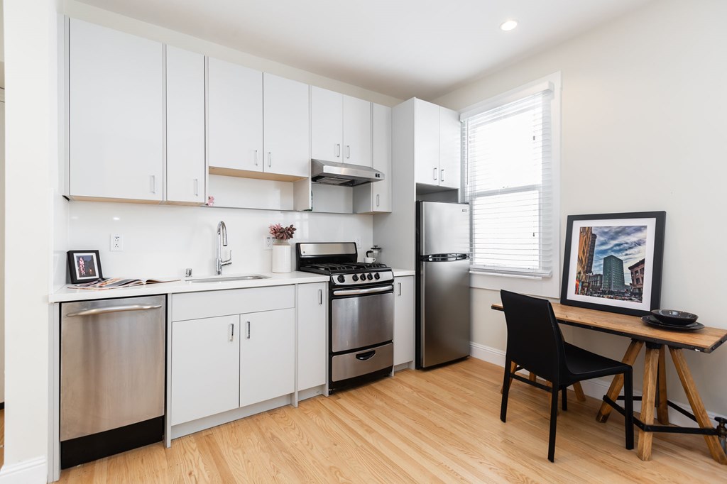 a kitchen with white cabinets and stainless steel appliances