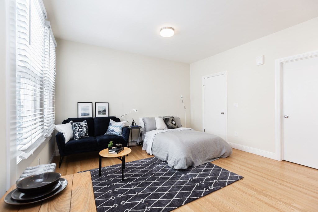 a bedroom with a bed and a black couch