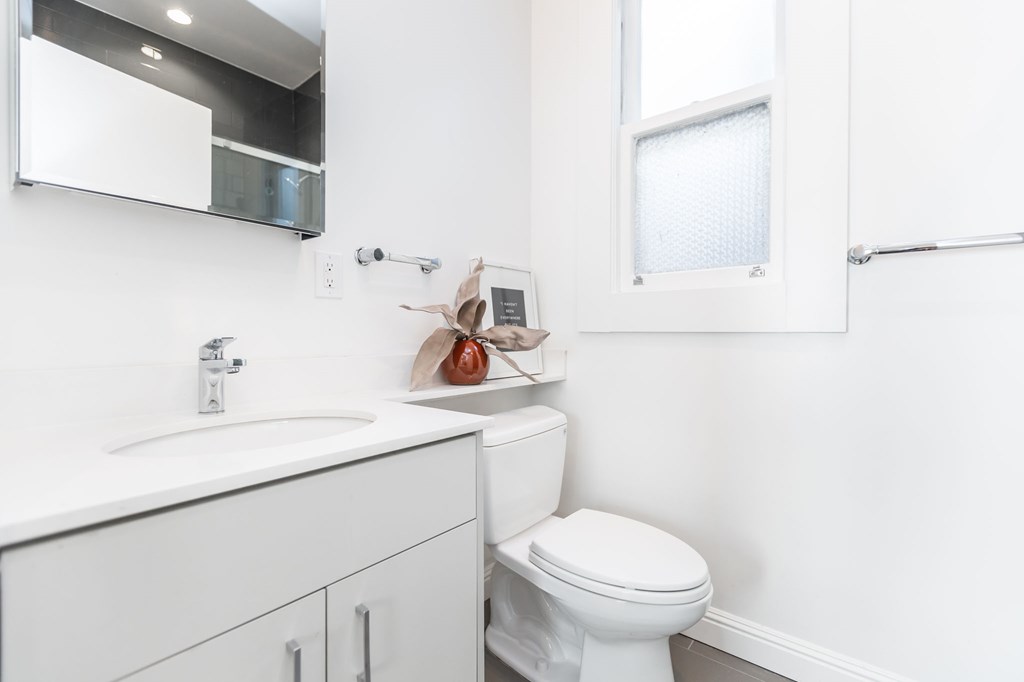 a bathroom with a toilet sink and a mirror