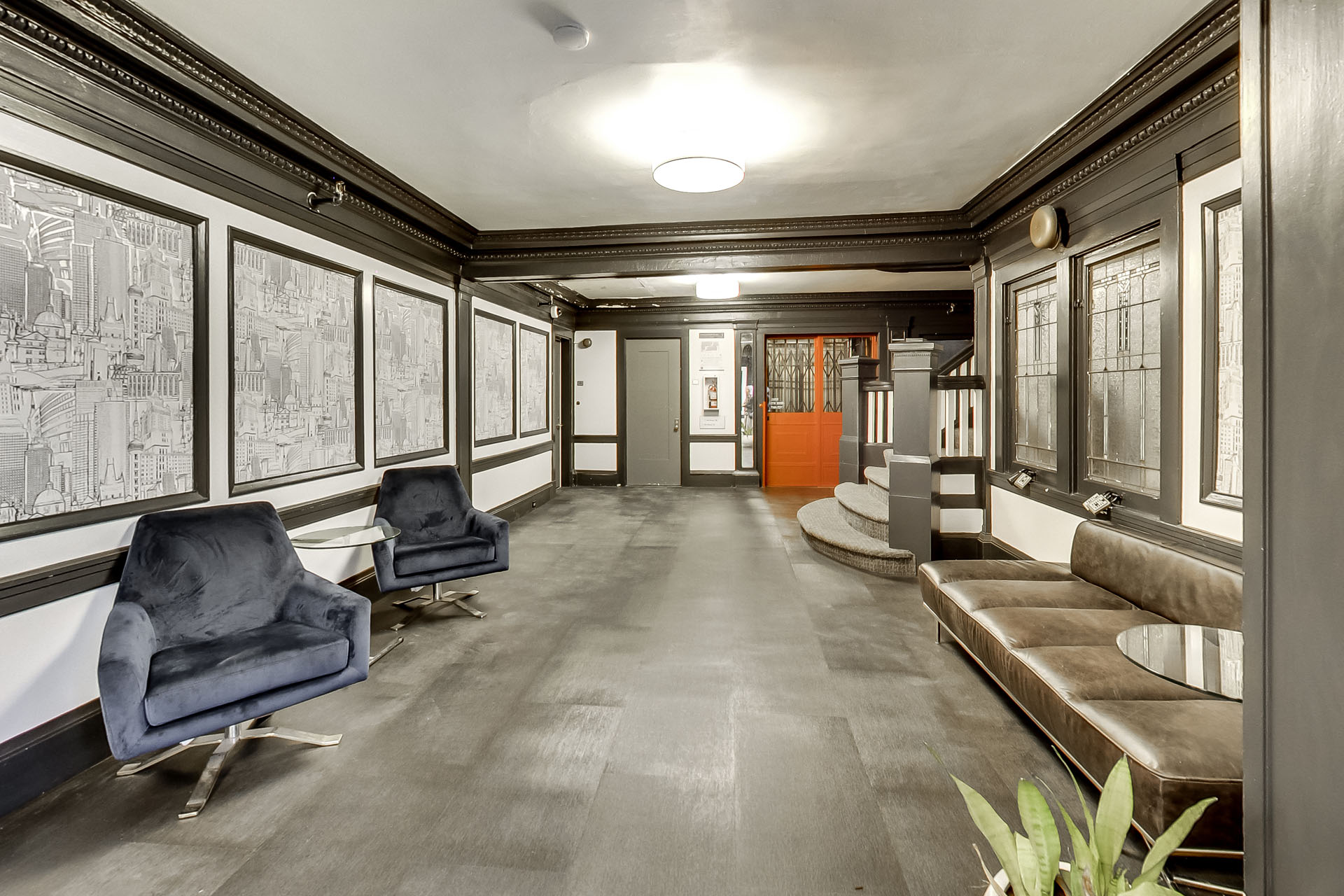 A long hallway with chairs and a bench on the right side.