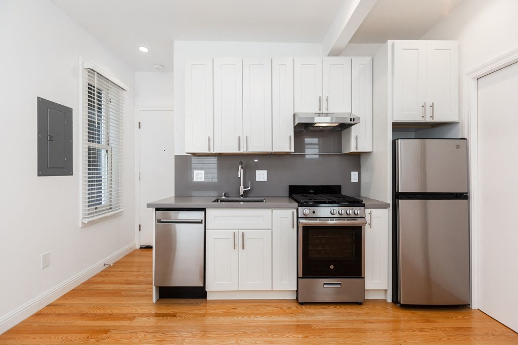 A modern kitchen with stainless steel appliances and white cabinets.