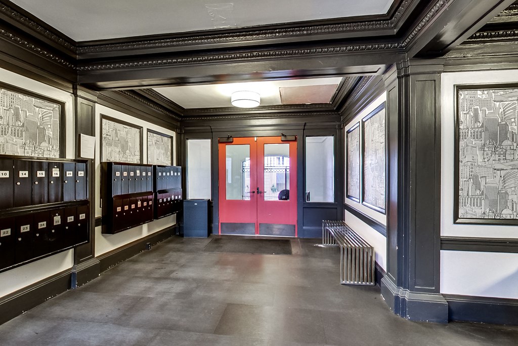 A room with a red door and pictures on the wall.