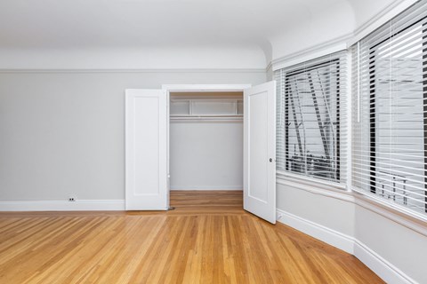 A room with a white door and a window with blinds.