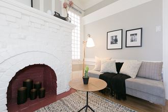 a living room with a white brick fireplace and a couch