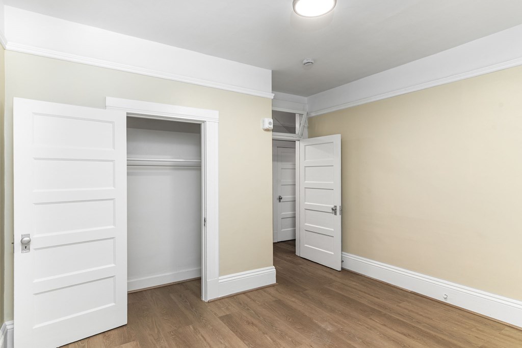 A room with two white doors and a light on the ceiling.