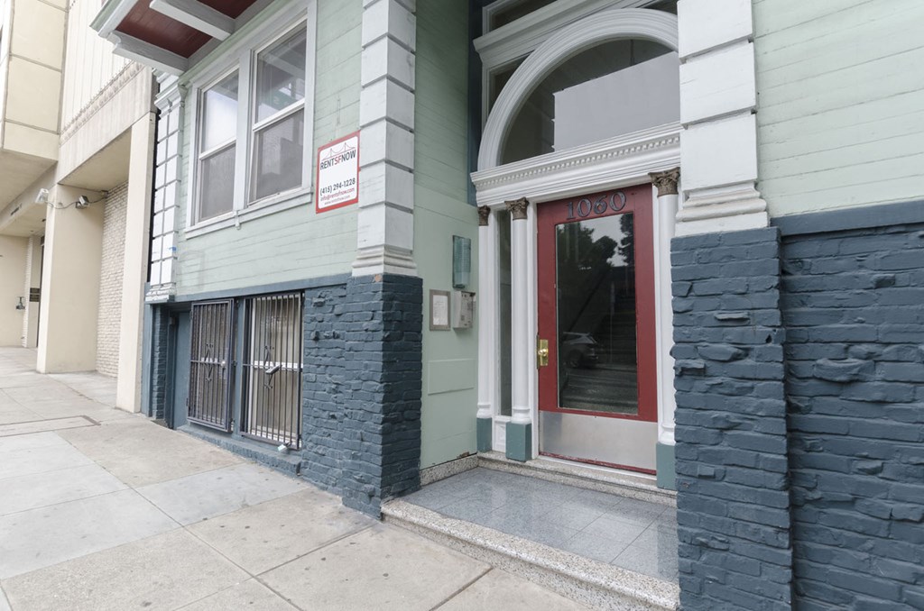 A building with a red door and a sign on the window.