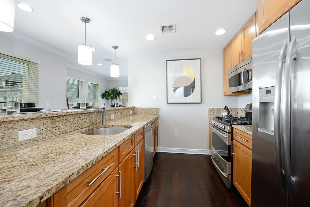 a kitchen with granite counter tops and stainless steel appliances