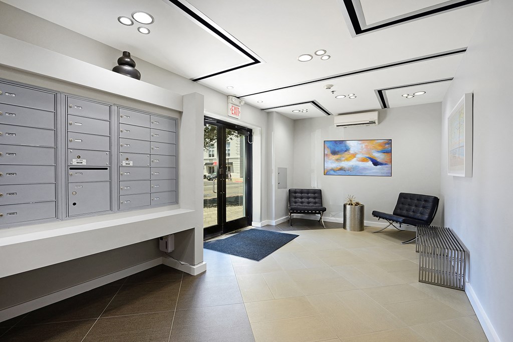 a hallway with two chairs and a cabinet with mailboxes